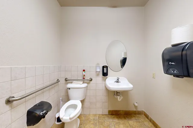 a bathroom with a sink mirror and toilet