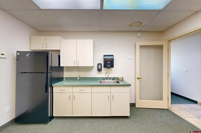 a kitchen with a refrigerator sink and cabinets