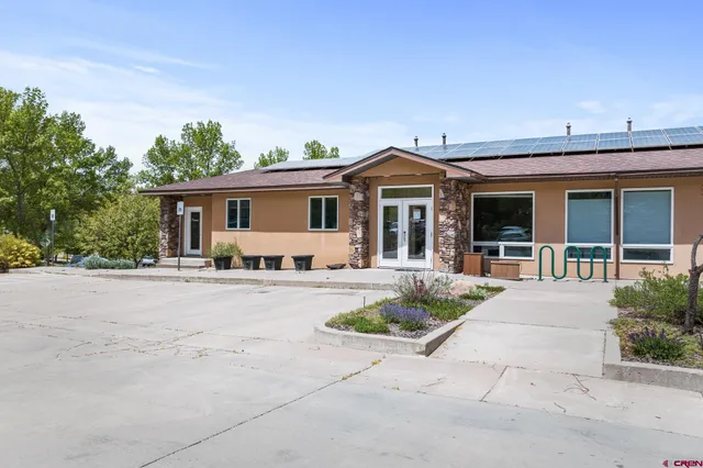 a front view of a house with yard and parking