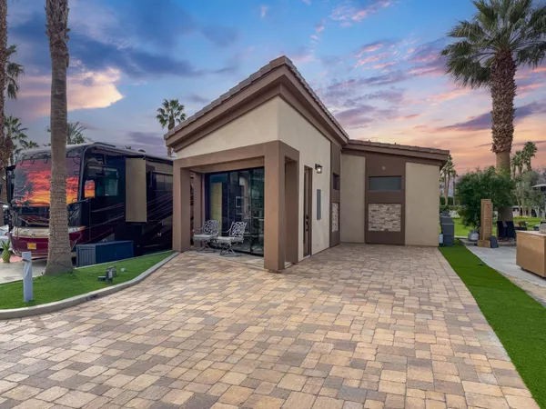 a view of a house with a yard and potted plants