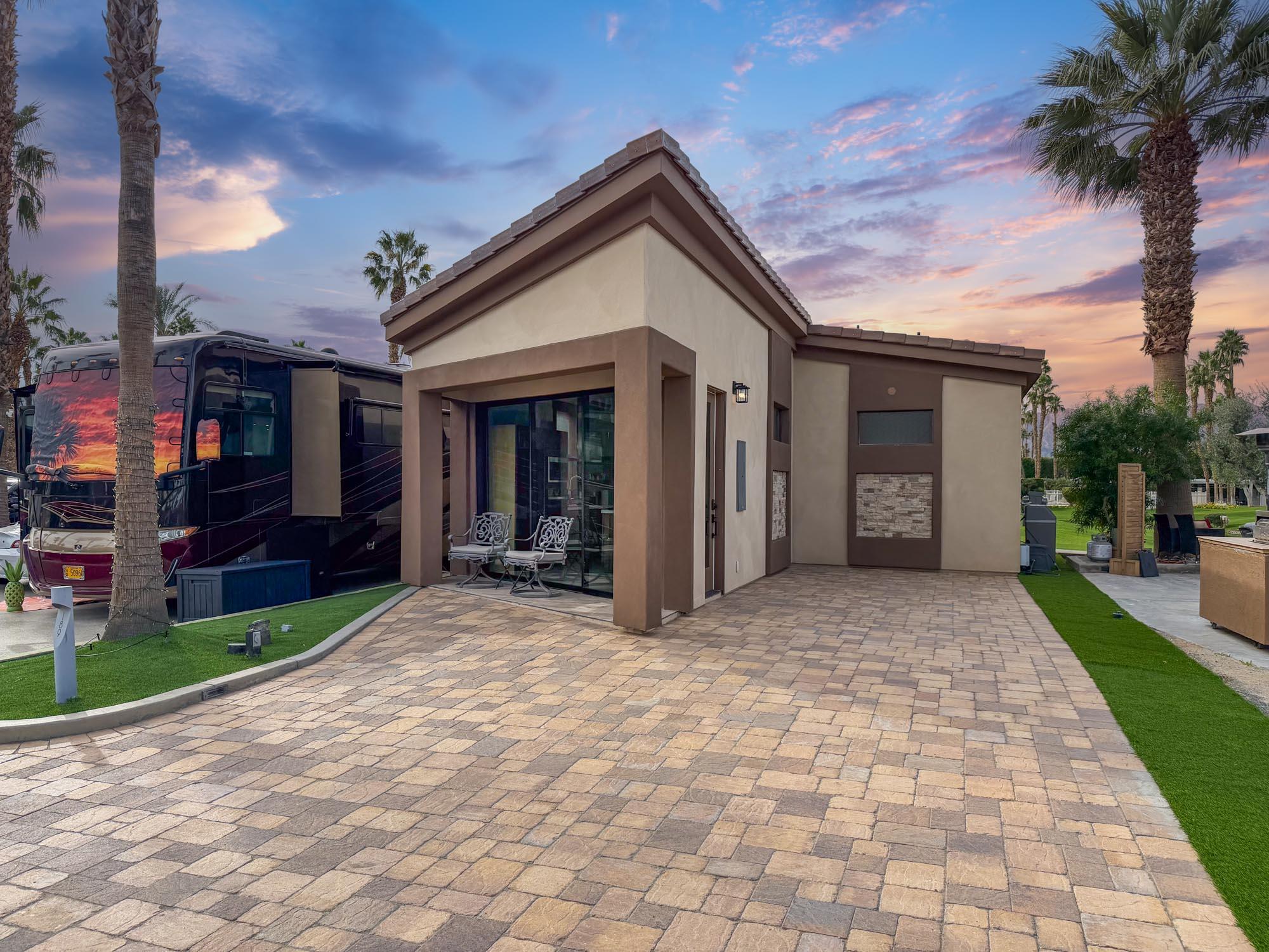 a view of a house with a yard and potted plants