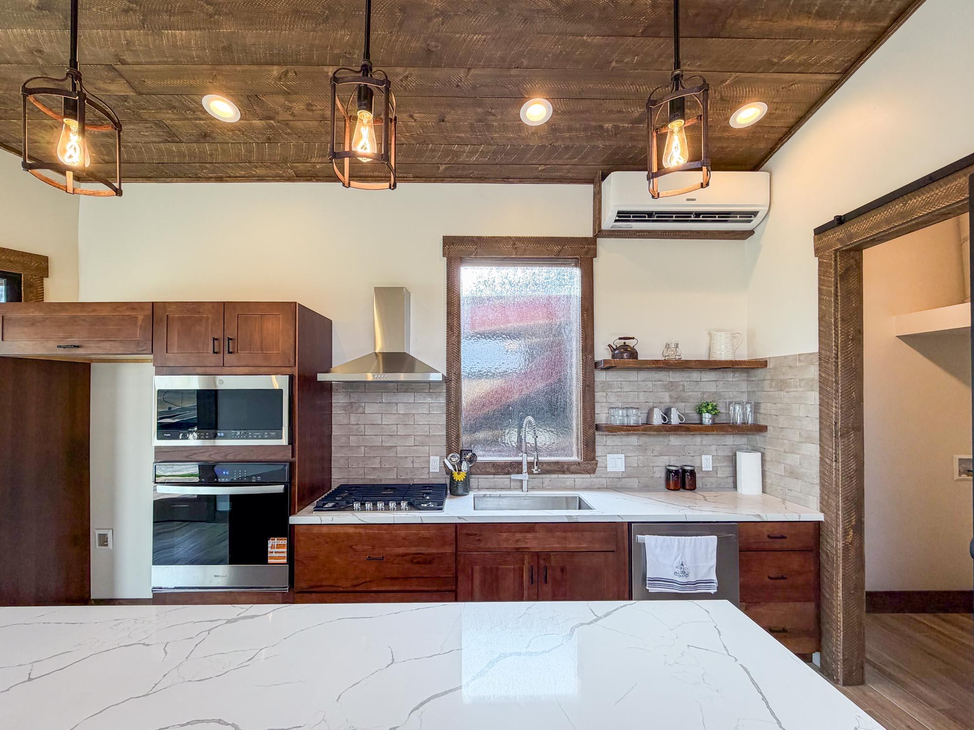 80394 Ave 48, Unit 189 Indio, CA 92201 - Photo 5 of 16 a large kitchen with stainless steel appliances kitchen island granite countertop a stove and large cabinets