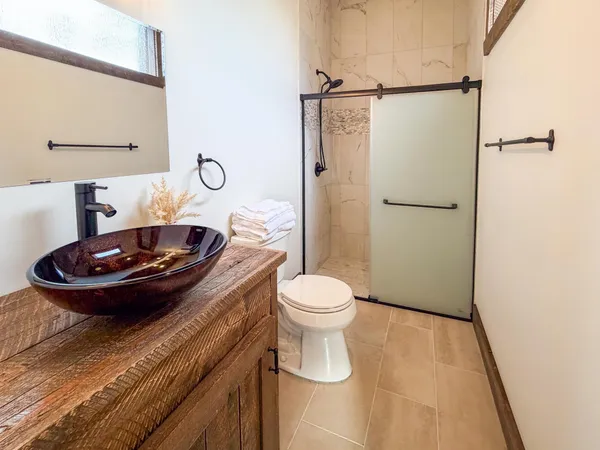 a bathroom with a granite countertop sink toilet and shower