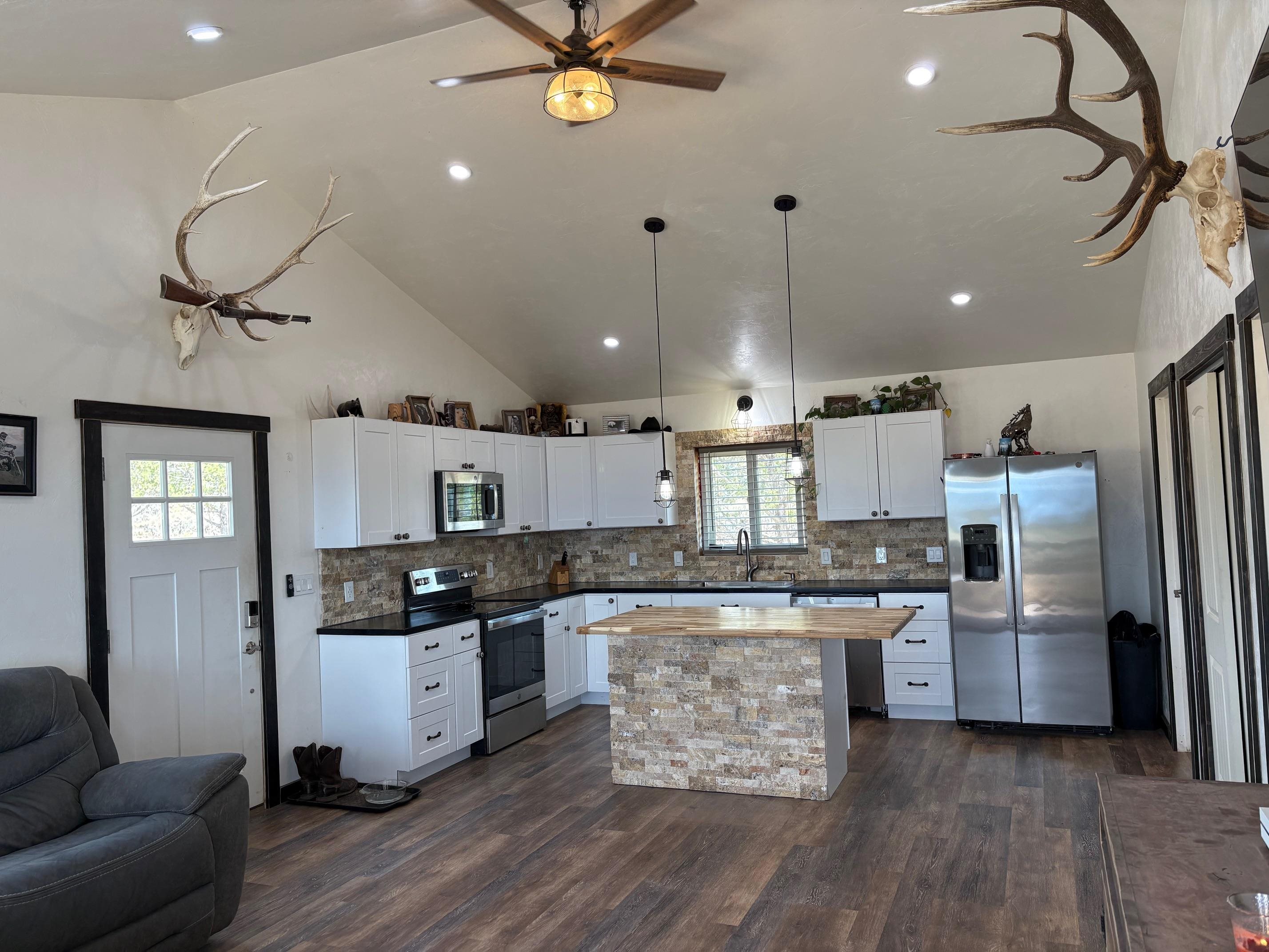 24500 Timothy Road Cedaredge, CO 81413 - Photo 2 of 33 a kitchen with stainless steel appliances kitchen island a refrigerator and a stove top oven