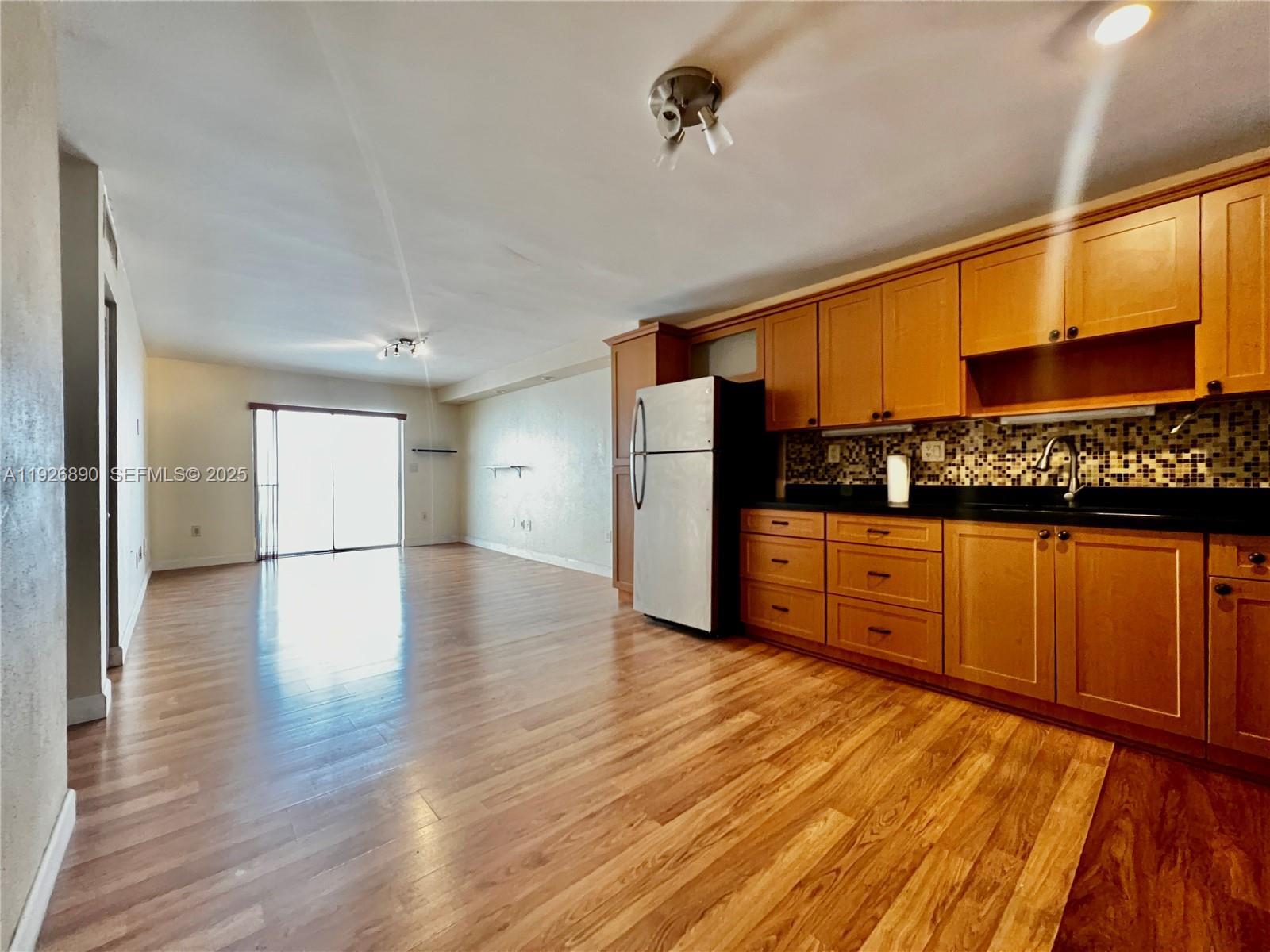 a view of a kitchen with cabinets and wooden floor