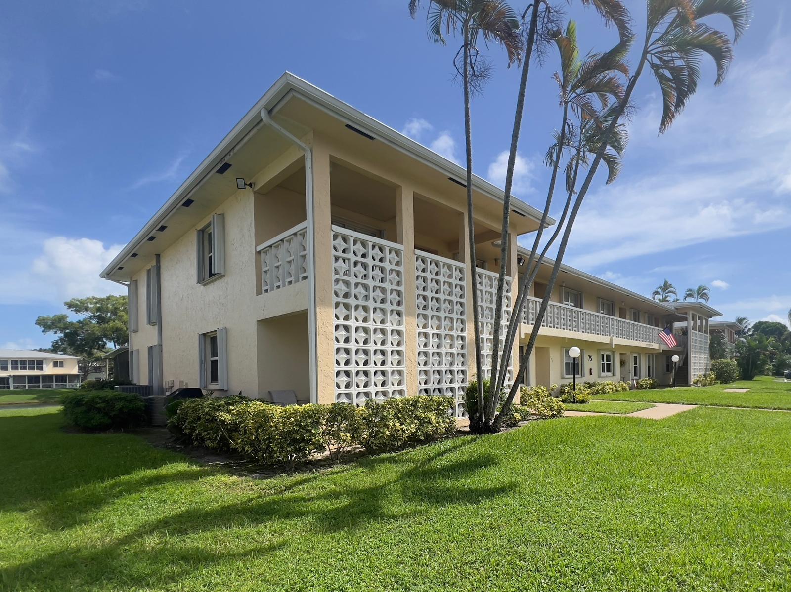 1421 Northwest 19th Terrace, Unit 102 Delray Beach, FL 33445 - Photo 2 of 31 a front view of a house with a yard