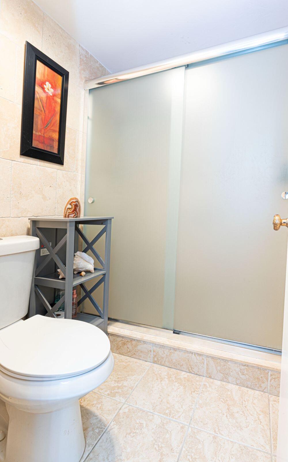 1421 Northwest 19th Terrace, Unit 102 Delray Beach, FL 33445 - Photo 10 of 31 a bathroom with a toilet a sink and a shower