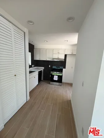 a kitchen with cabinets and wooden floor