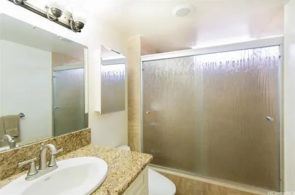 a bathroom with a granite countertop sink toilet and shower