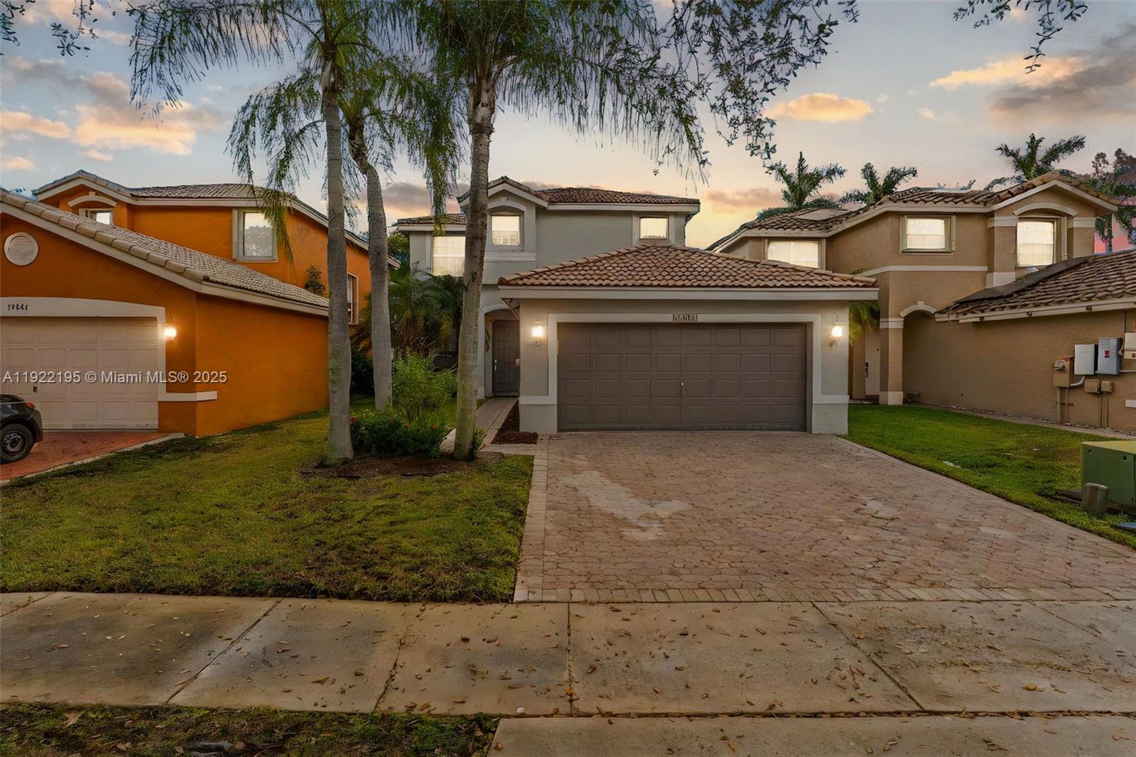 a front view of a house with a yard and a garage