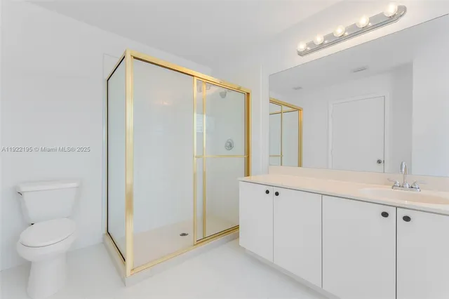 a spacious bathroom with a granite countertop sink a toilet and a mirror