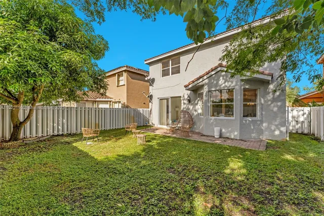 a backyard of a house with table and chairs