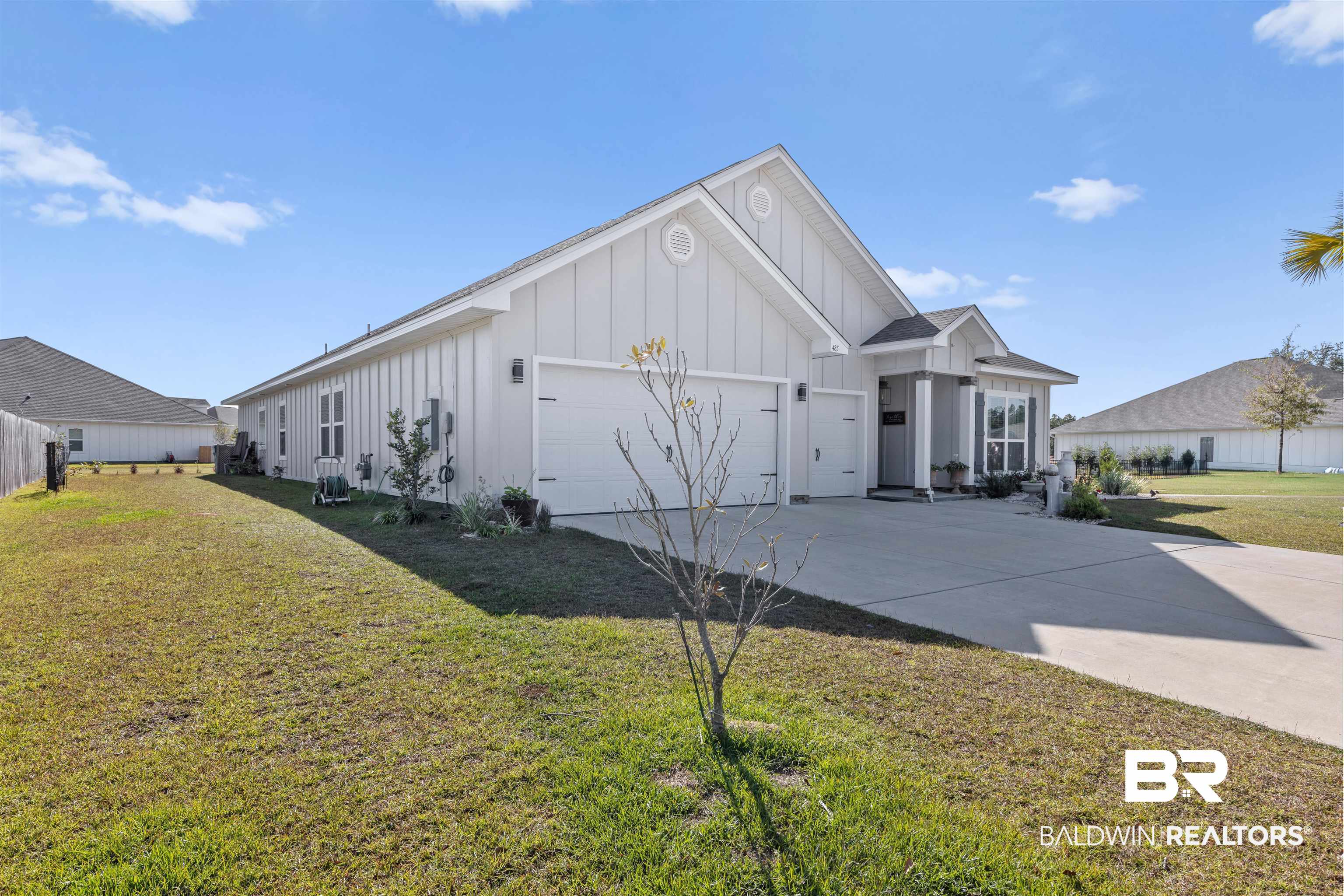 485 Shepard Street Gulf Shores, AL 36542 - Photo 2 of 53 View of front of house featuring board and batten siding, a front yard, a garage, and concrete driveway