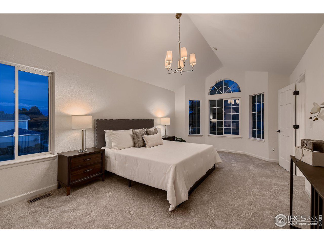1285 Eldorado Drive Superior, CO 80027 - Photo 23 of 29 a bedroom with a large bed and a chandelier