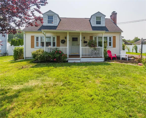 a view of a house with a big yard and large tree