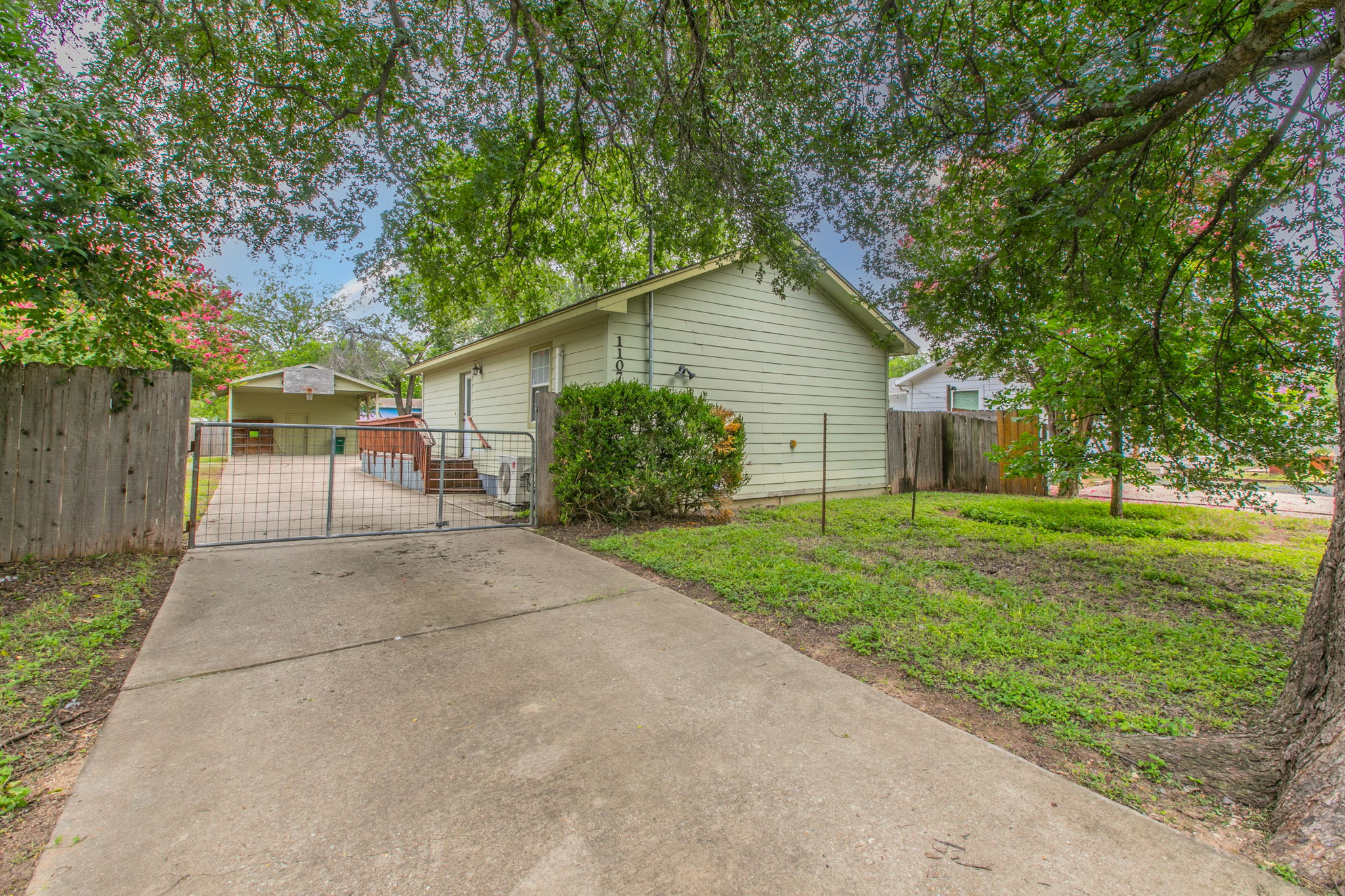 1107 Vargas Road Austin, TX 78741 - Photo 16 of 17 A private gated driveway leads to this charming home with a spacious backyard, surrounded by lush, mature trees.