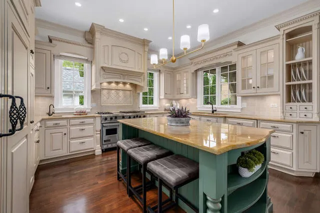 a kitchen with granite countertop a stove a sink and a refrigerator