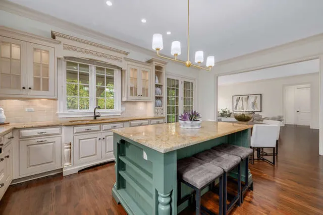 a kitchen with center island table and chairs