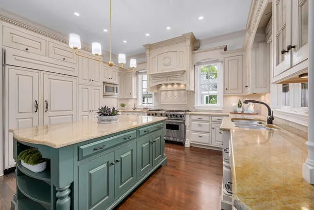 a kitchen with kitchen island granite countertop a sink stainless steel appliances and cabinets