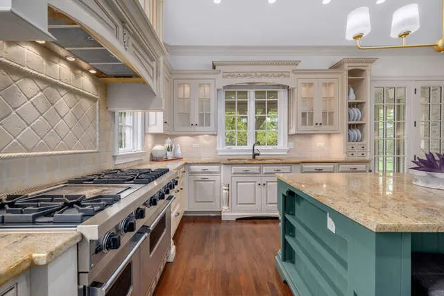 a kitchen with granite countertop a sink stove and cabinets