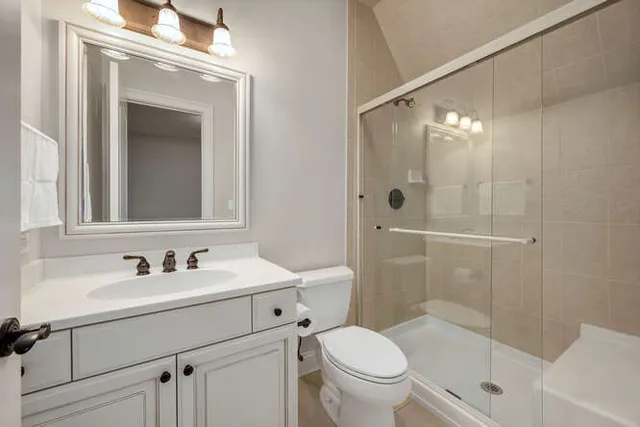 a bathroom with a sink a toilet and shower