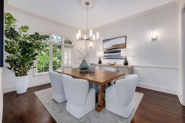 a dining room with furniture potted plants and wooden floor