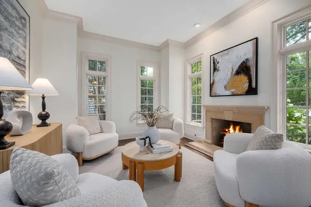 a living room with furniture a fireplace and a large window