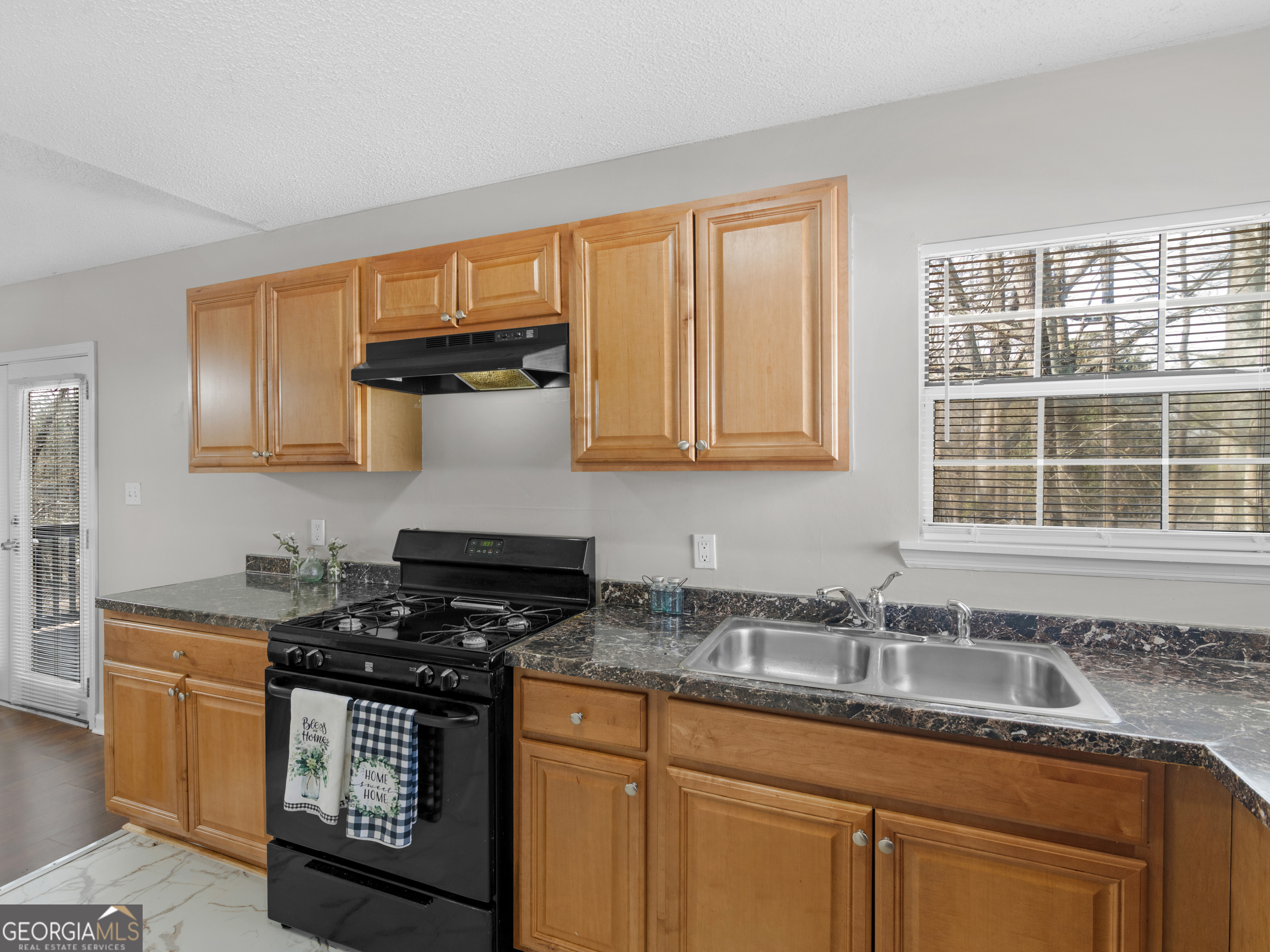 111 Neal Avenue Stockbridge, GA 30281 - Photo 10 of 27 a kitchen with granite countertop a sink stove and cabinets