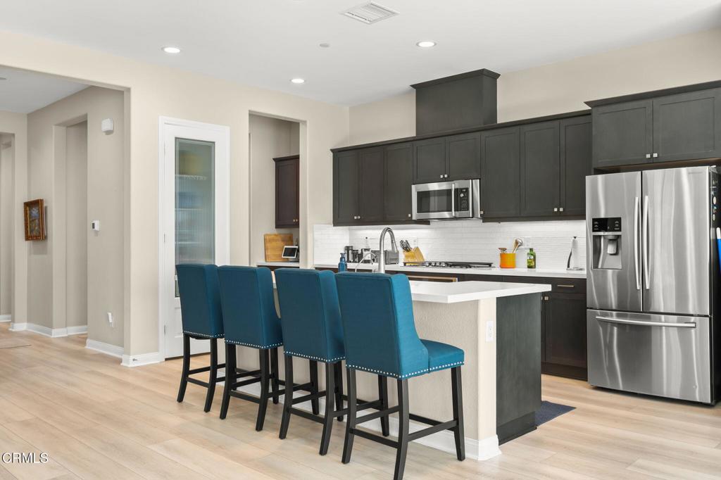 390 Rose Street Fillmore, CA 93015 - Photo 10 of 58 a kitchen with a table chairs refrigerator and microwave