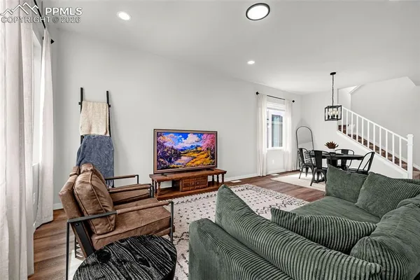 a living room with furniture a flat screen tv and a window