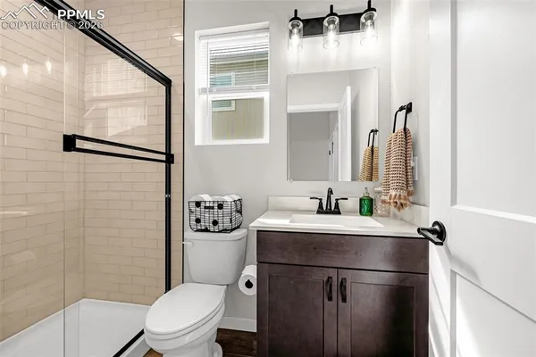 a bathroom with a granite countertop sink toilet and shower