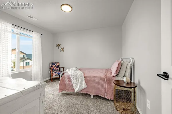 a view of a bedroom with furniture and window
