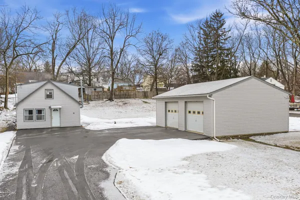 a view of a white house with a yard covered with snow in front of it