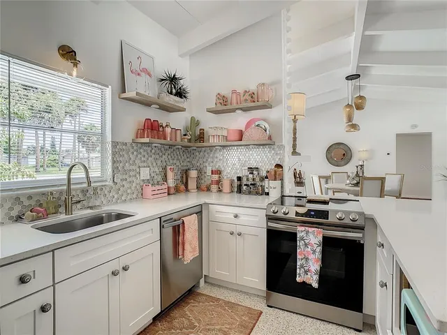 a kitchen with a refrigerator a stove a sink dishwasher and white cabinets with wooden floor