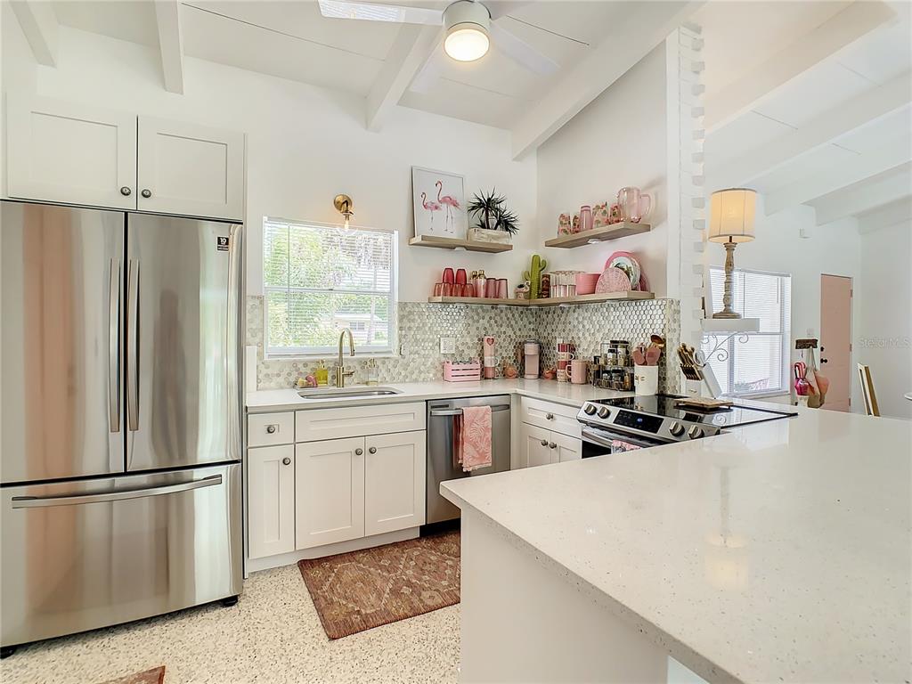 3228 Webber Street Sarasota, FL 34239 - Photo 17 of 39 a kitchen with a refrigerator a stove a sink dishwasher and white cabinets with wooden floor