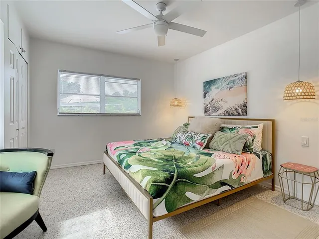 a bedroom with a bed and a refrigerator