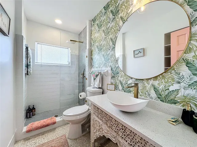 a bathroom with a sink a toilet and shower