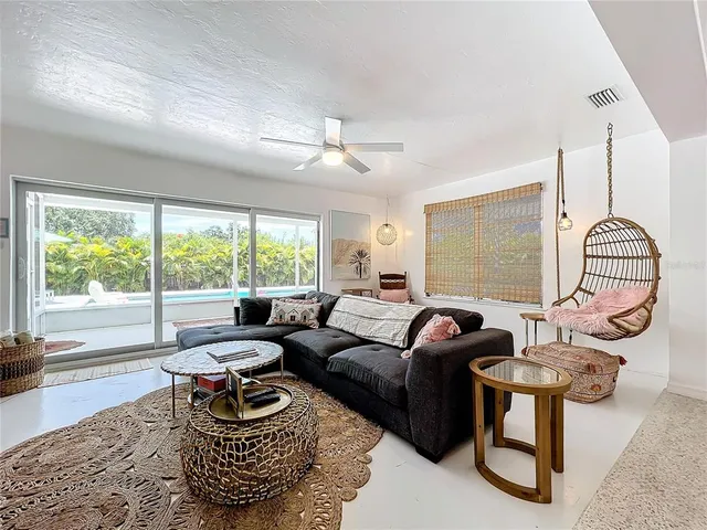 a living room with furniture potted plant and a large window