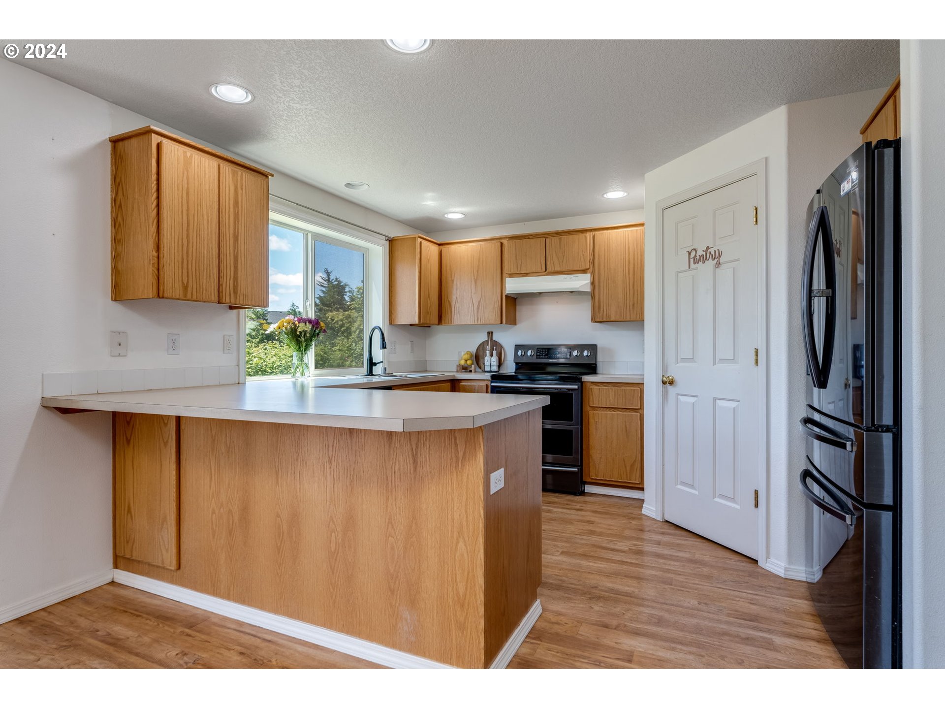 805 Raven Drive Ridgefield, WA 98642 - Photo 8 of 35 a kitchen with stainless steel appliances granite countertop a refrigerator sink and cabinets
