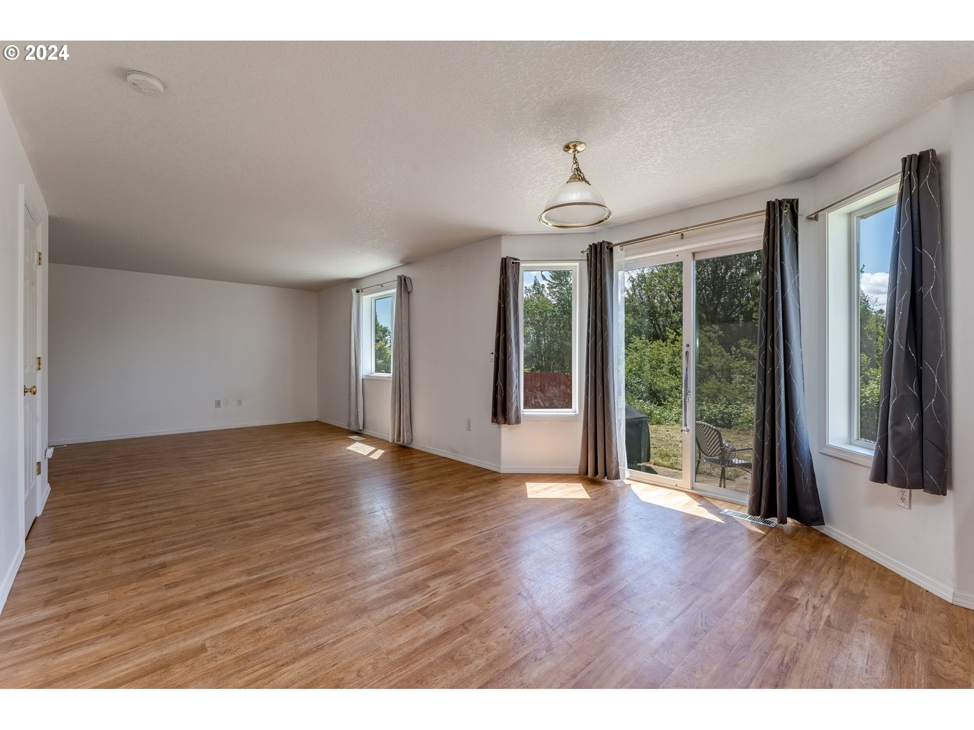 805 Raven Drive Ridgefield, WA 98642 - Photo 10 of 35 a view of an empty room with wooden floor and a window
