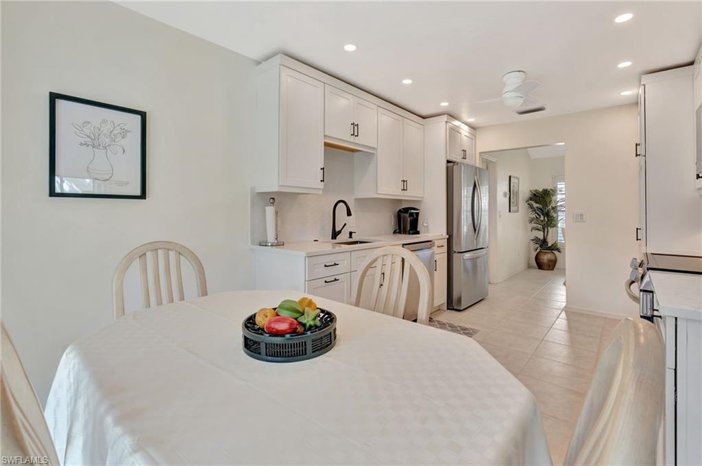 731 Reef Point Circle Naples, FL 34108 - Photo 15 of 47 a kitchen with stainless steel appliances a sink a microwave a refrigerator and cabinets