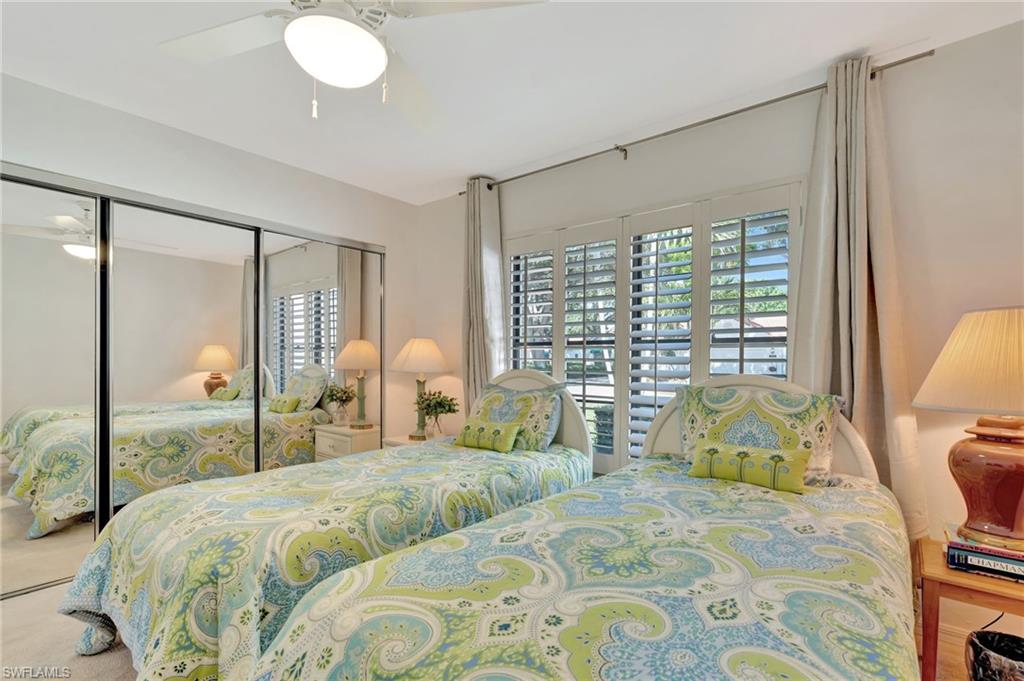 731 Reef Point Circle Naples, FL 34108 - Photo 18 of 47 a bedroom with a large bed and a chandelier