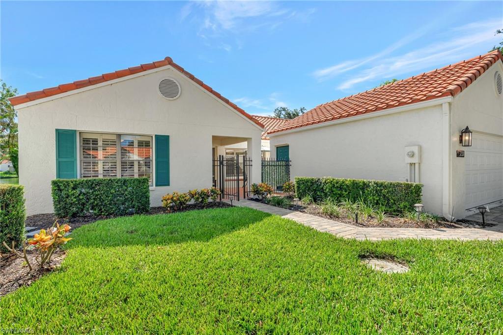 731 Reef Point Circle Naples, FL 34108 - Photo 2 of 47 a front view of a house with a yard