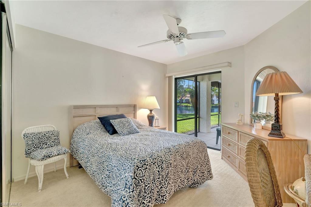 731 Reef Point Circle Naples, FL 34108 - Photo 21 of 47 a bedroom with a bed lamps and table