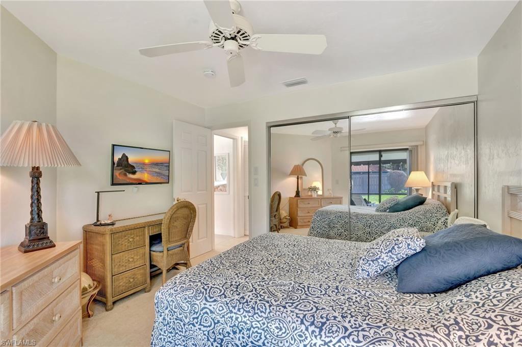 731 Reef Point Circle Naples, FL 34108 - Photo 22 of 47 a bedroom with a bed a desk and dresser with mirror