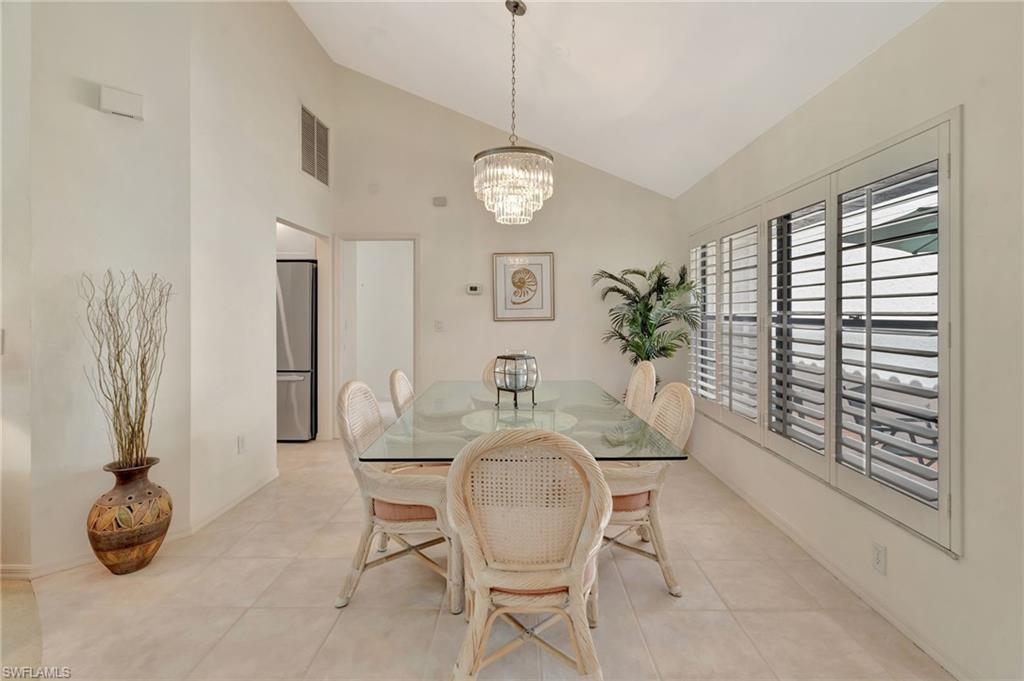 731 Reef Point Circle Naples, FL 34108 - Photo 8 of 47 a dining room with furniture and a chandelier