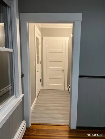 a view of a hallway with wooden floor and staircase