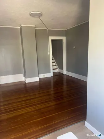 a view of an empty room with wooden floor