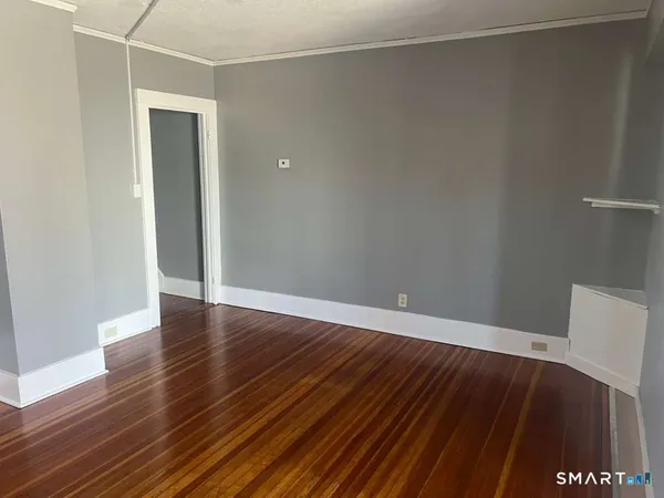 a view of an empty room with wooden floor