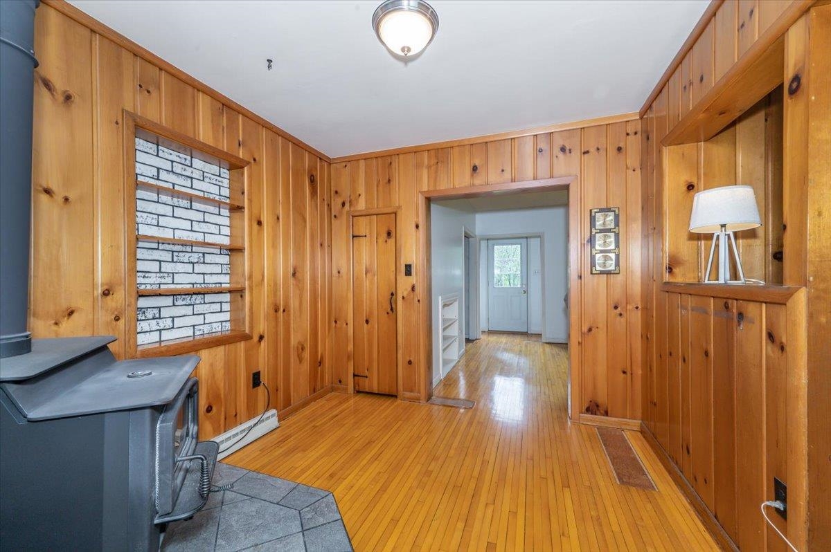 5253 Midway Road Duluth, MN 55811 - Photo 4 of 28 Foyer featuring wooden walls, light wood-type flooring, a baseboard heating unit, and ornamental molding